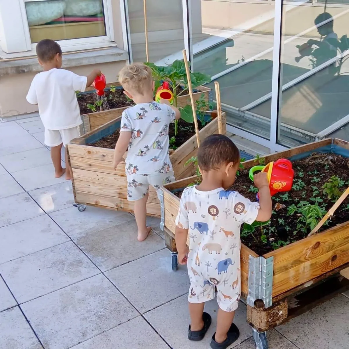 Des enfants du RPE arrosent le potager partagé