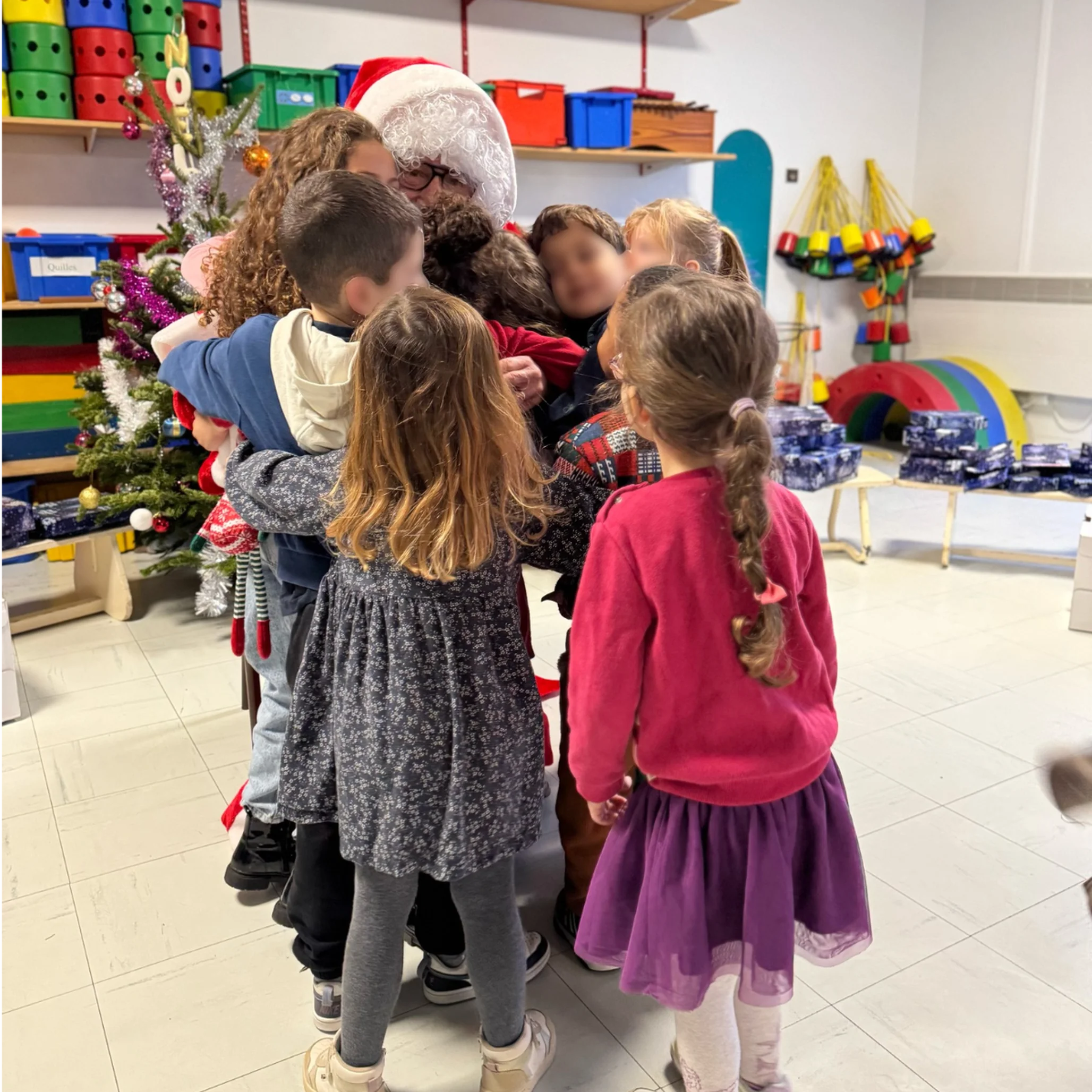 Les enfants font un câlin au Père Noël.